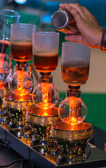 Siphon vacuum coffee maker and coffee grinder with drip brewing filtered coffee or pour-over is a method involves pouring hot water over roasted coffee beans contained in a filter old tradition