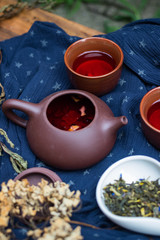 Asian tea ceremony. Japanese, Chinese and Thai traditional tea ceremony with pot and small cups. Herbal green and black Chinese tea leaves, aromatic drink, authentic