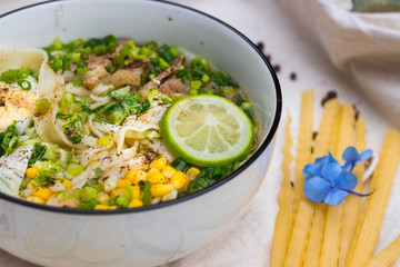 Ramen noodle soup with egg, corn and meat in bowl. Asian Thai traditional authentic food with vegetables served in cafe or restaurant