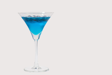 a glass of blueberry in blue water on white background with clipping path
