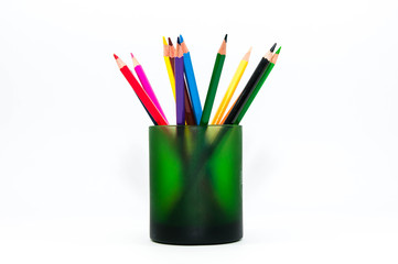 Color pencils in a green cup close up shot isolated on white background.