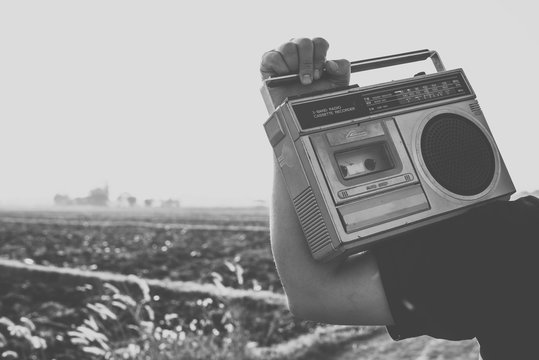 Photo of memorie and nostalgia. people with vintage radio or cassette reccorder in countryside. black and white color tone.