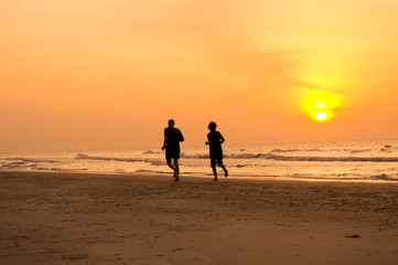 Naklejka premium people running on the beach at the morning