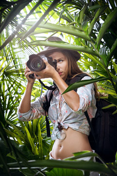 portrait of nice young woman is taking picture in the  jungle
