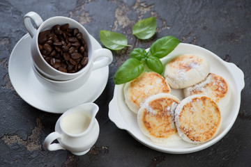 Curd fritters with coffee for breakfast over brown stone background, horizontal shot