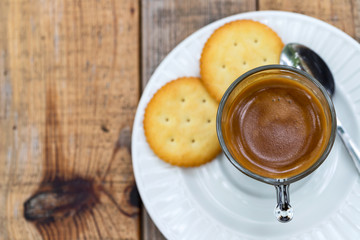 Hot coffee in glass placed on the table with cookies.