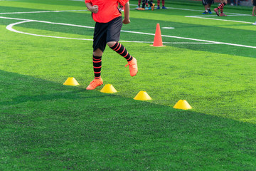 Obraz premium Soccer Football Training Session for Kid. Asian Boy Training Football on the Pitch.