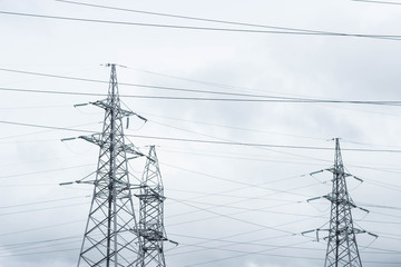 Three electric towers on the sky background, tension