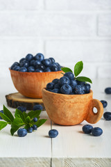 Blueberries with leaves in a clay cup © Marta Teron