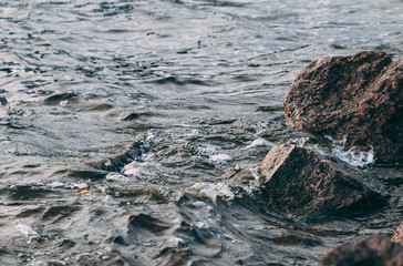 Stone shore and waves of the Gulf of Finland. North nature. Close-up view.