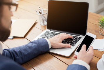 Unrecognizable businessman typing on laptop