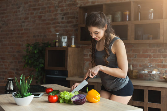 Happy woman preparing healthy food in the home kitchen