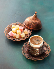 Traditional turkish coffee  and turkish delight on dark green wooden background.