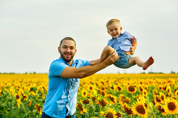 Happy father playing with his son on a summer walk . The parent throws his son up