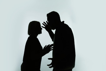 Silhouette of couple having argument on color background. Relationship problems