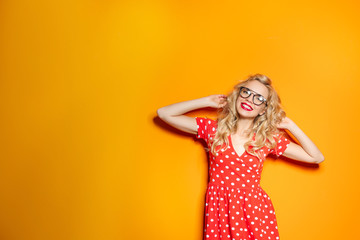 Stylish young woman with glasses posing on color background