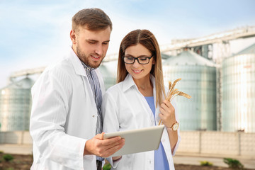 Young agronomists near modern granaries. Cereal farming