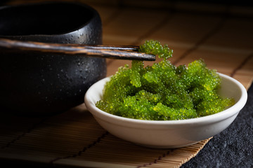 Oval sea grapes seaweed, Close up Green Caviar on dark background