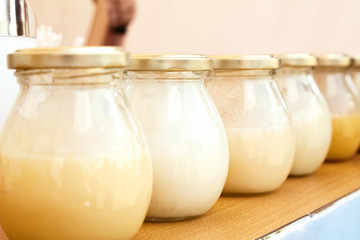 Row of glass jars with honey at a farmers food market. Many bottles with sweet natural honey of...