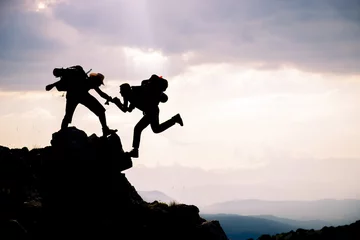 Deurstickers adventurous people Hikers climbing on mountain. Help, risk, support, assistance © emerald_media