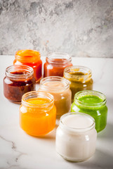 Variety of homemade baby vegetable and fruit puree,  white marble background copy space