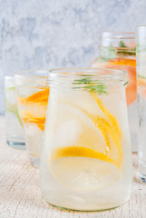 Summer healthy cocktails, set of various citrus infused waters, lemonades or mojitos, with lime lemon orange grapefruit, diet detox beverages, in different glasses light background copy space