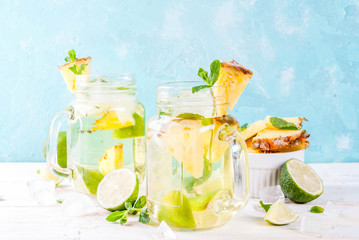 SONY DSCTropical drink,  Pineapple mojito or lemonade with fresh lime and mint  light blue background, copy space
