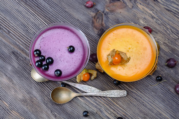 Colorful multi-layered jelly in a glass  is on a white wooden table 