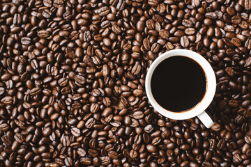 coffee in a cup on coffee beans background. refreshment and favourite drink concept