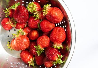 Strawberries in colander on white background
