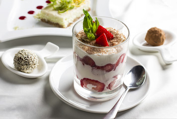 Sweet table with organic raw food desserts, sweets, yogurt with strawberries, cake