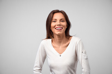 Obraz premium People, beauty and lifestyle concept. Shot of attractive sensual woman with wide smile dressed in white T-shirt smiling broadly being happy to meet her best friend. Joyful nice female