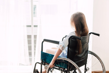 Fototapeta na wymiar Little girl sitting on wheelchair in the hospital