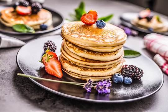 Pancakes with strawberries blackberries blueberries and lavender.