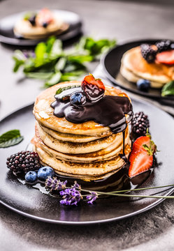 Pancakes with strawberries blackberries blueberries and lavender.
