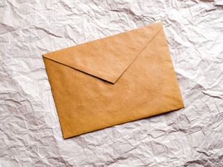envelope of Kraft paper lies on crumpled paper.