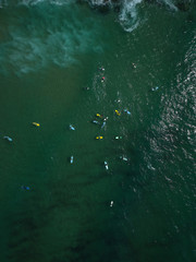 Aerial view of surfers in the ocean on a summer day. Surf Spot on the Portuguese coastline. Drone shot.