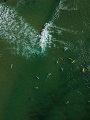 Aerial view of surfers in the ocean on a summer day. Surf Spot on the Portuguese coastline. Drone shot.
