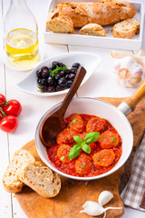 Baked mini meatballs in tomato sauce with basil