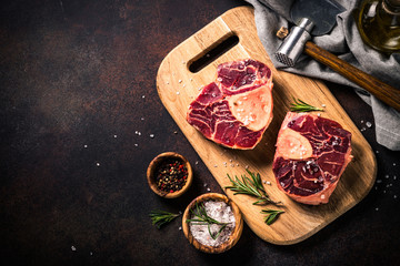 Raw beef steak osso bucco on cutting board.