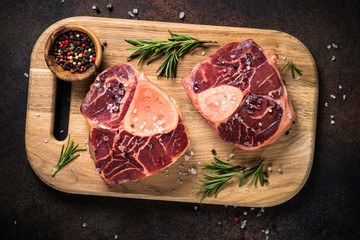 Raw beef steak osso bucco on cutting board.