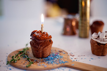 tasty birthday cupcake with candle on the table, blurred background