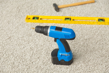 Hammer, drill and builders level on the floor