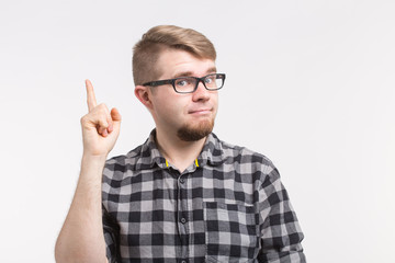 Naklejka premium Portrait of a young man having idea and pointing finger up isolated on the white background