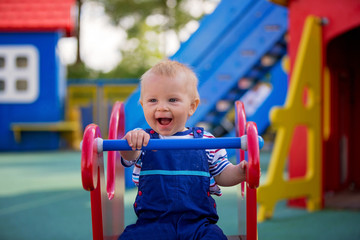 Fototapeta na wymiar Adorable little 1-2 year old toddler boy having fun on playground, child playing