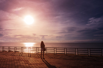Young beautiful women looking at the sea beach in sunrise time, relax and enjoy life alone. Freedom...