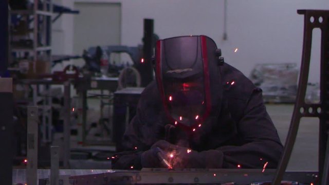 small business industrial worker at factory shop welding steel slow motion