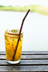 Fresh passion fruit juice and haft passion fruit on top with wooden table background. Hipster style.