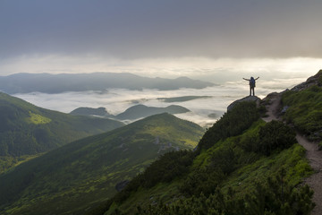 Wide mountain panorama. Small silhouette of tourist with backpack on rocky mountain slope with...