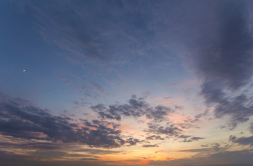 Panorama of sky at sunrise or sunset. Beautiful view of dark blue clouds lit by bright orange...